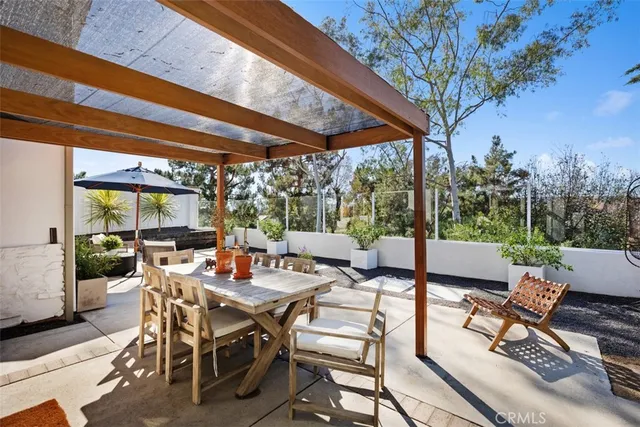 a view of a patio with table and chairs potted plants with wooden floor and fence