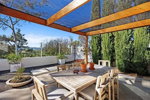 a view of a patio with couches table and chairs under an umbrella