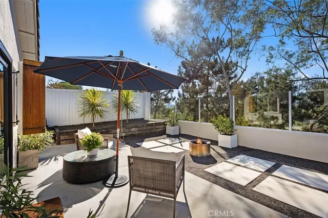 a view of a patio with chairs and table under an umbrella