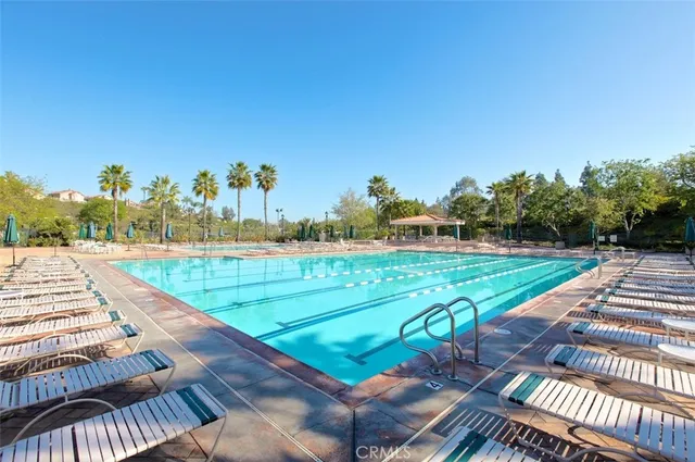 a view of a swimming pool with a lawn chairs under an umbrella