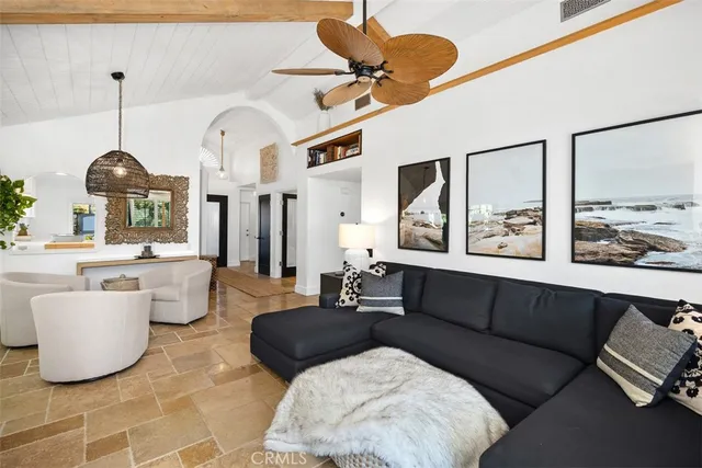 a living room with couches a fireplace and a potted plant