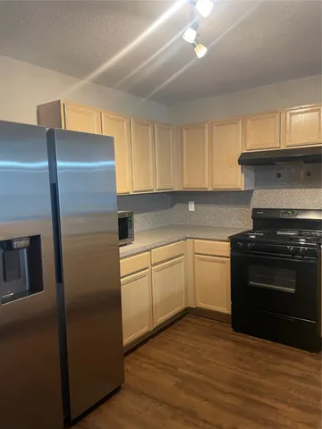 a kitchen with a refrigerator stove and cabinets