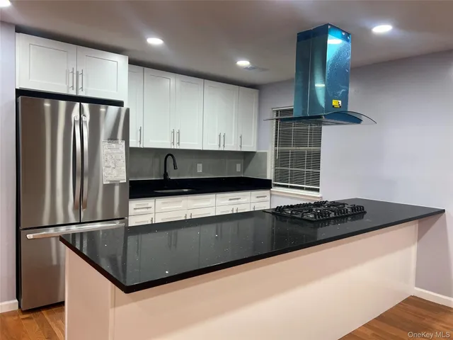 a kitchen with stainless steel appliances granite countertop a refrigerator a sink dishwasher a stove and a refrigerator