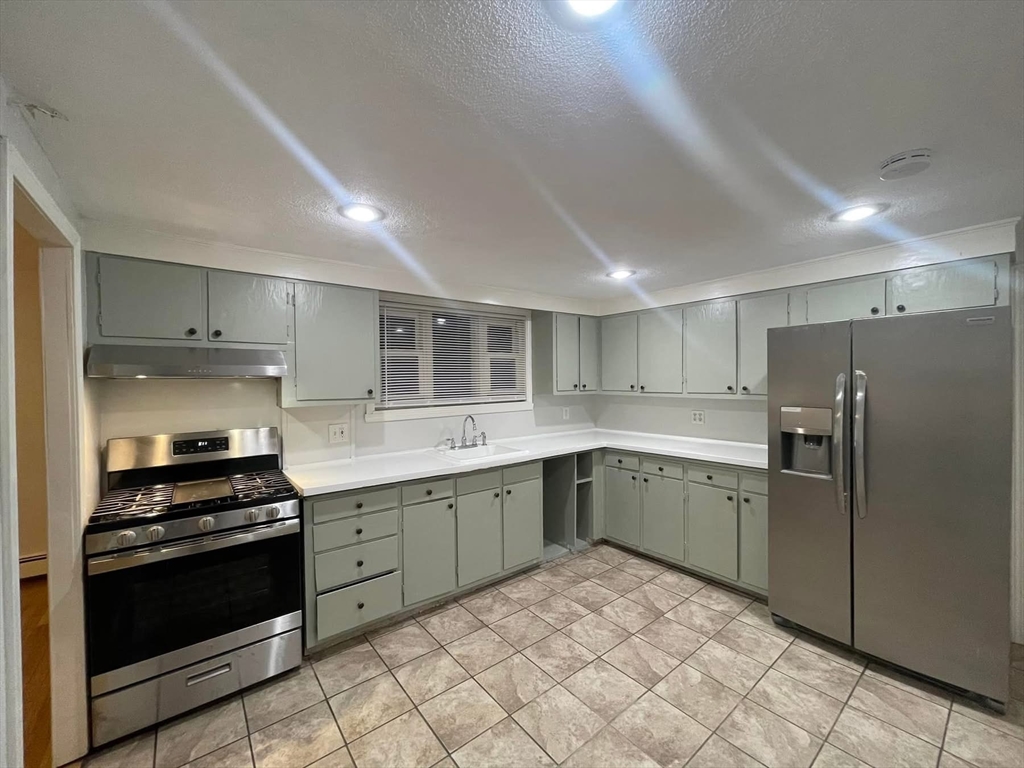 14 Irving Street, Unit 2 Everett, MA 02149 - Photo 1 of 5 a kitchen with a sink stainless steel appliances and cabinets