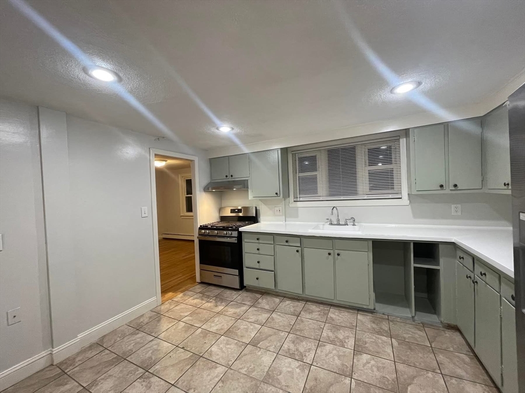 14 Irving Street, Unit 2 Everett, MA 02149 - Photo 2 of 5 a kitchen with a sink and chairs