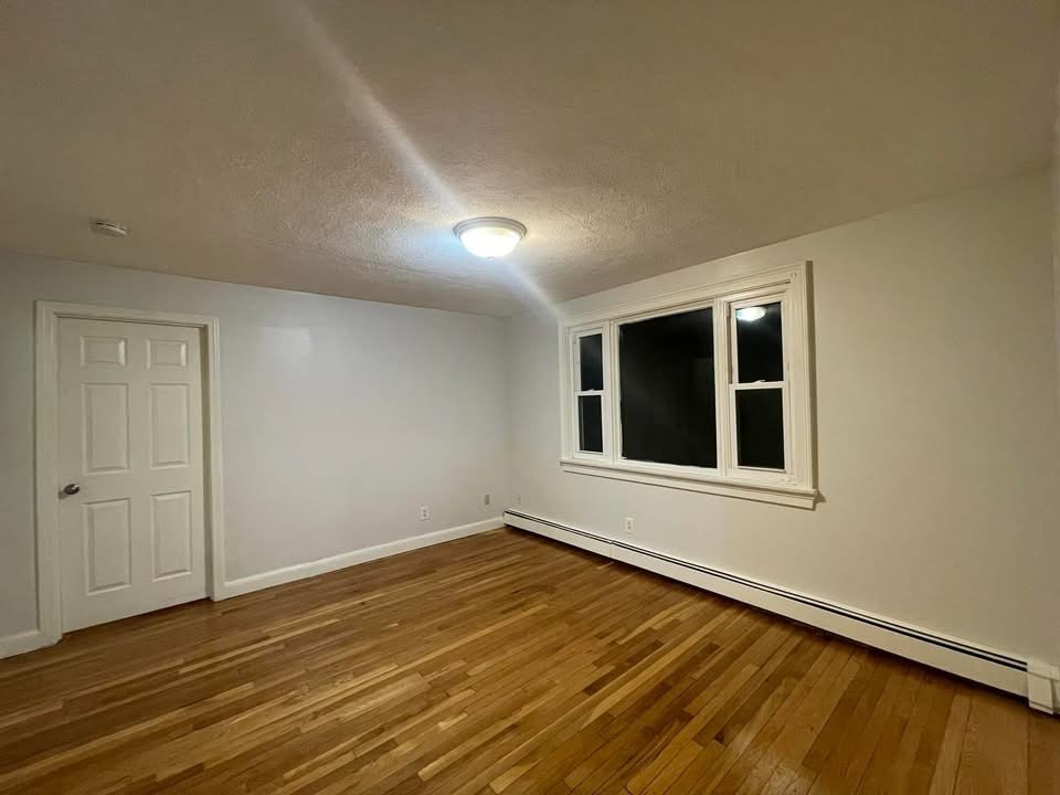 14 Irving Street, Unit 2 Everett, MA 02149 - Photo 4 of 5 a view of an empty room with wooden floor and a window