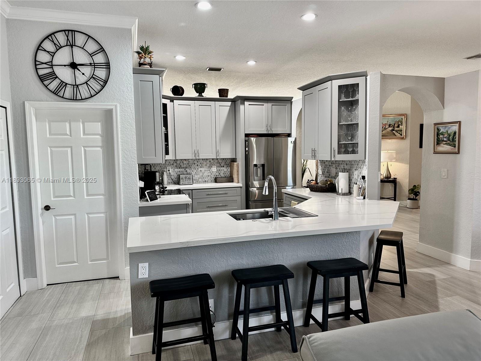 1335 East Barwick Ranch Circle Delray Beach, FL 33445 - Photo 12 of 33 a kitchen with a dining table chairs and refrigerator