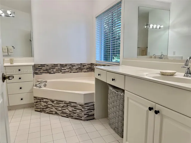 a bathroom with a bathtub a sink and a window