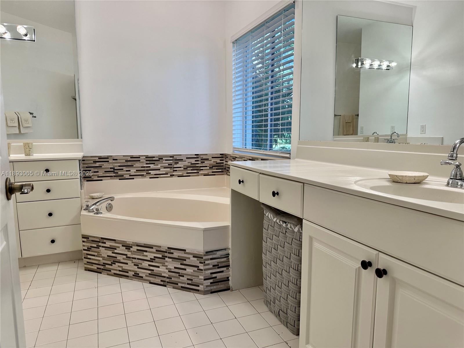 1335 East Barwick Ranch Circle Delray Beach, FL 33445 - Photo 19 of 33 a bathroom with a bathtub a sink and a window