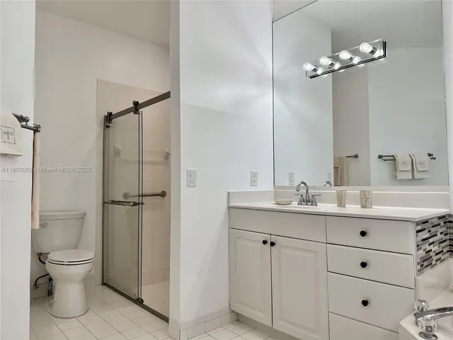 a bathroom with a double vanity sink toilet and shower