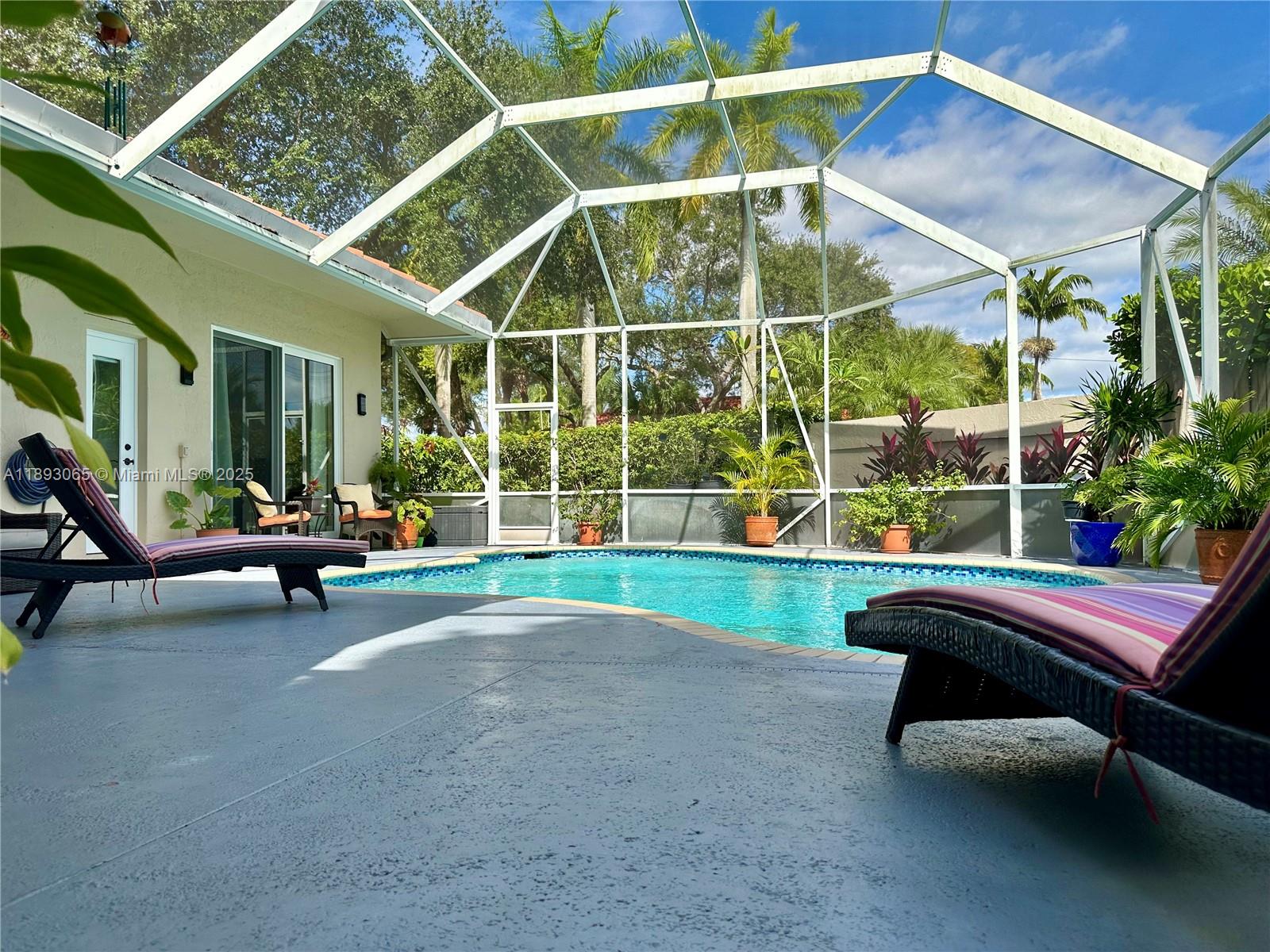 1335 East Barwick Ranch Circle Delray Beach, FL 33445 - Photo 2 of 33 a view of a swimming pool with lawn chairs and a yard