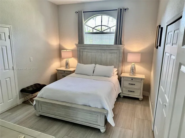 a bedroom with a bed and a large window