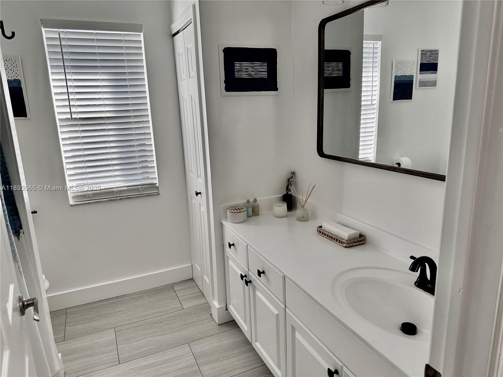 1335 East Barwick Ranch Circle Delray Beach, FL 33445 - Photo 26 of 33 a bathroom with a sink and a mirror