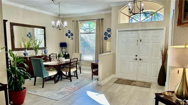 a view of a dining room with furniture a chandelier and wooden floor