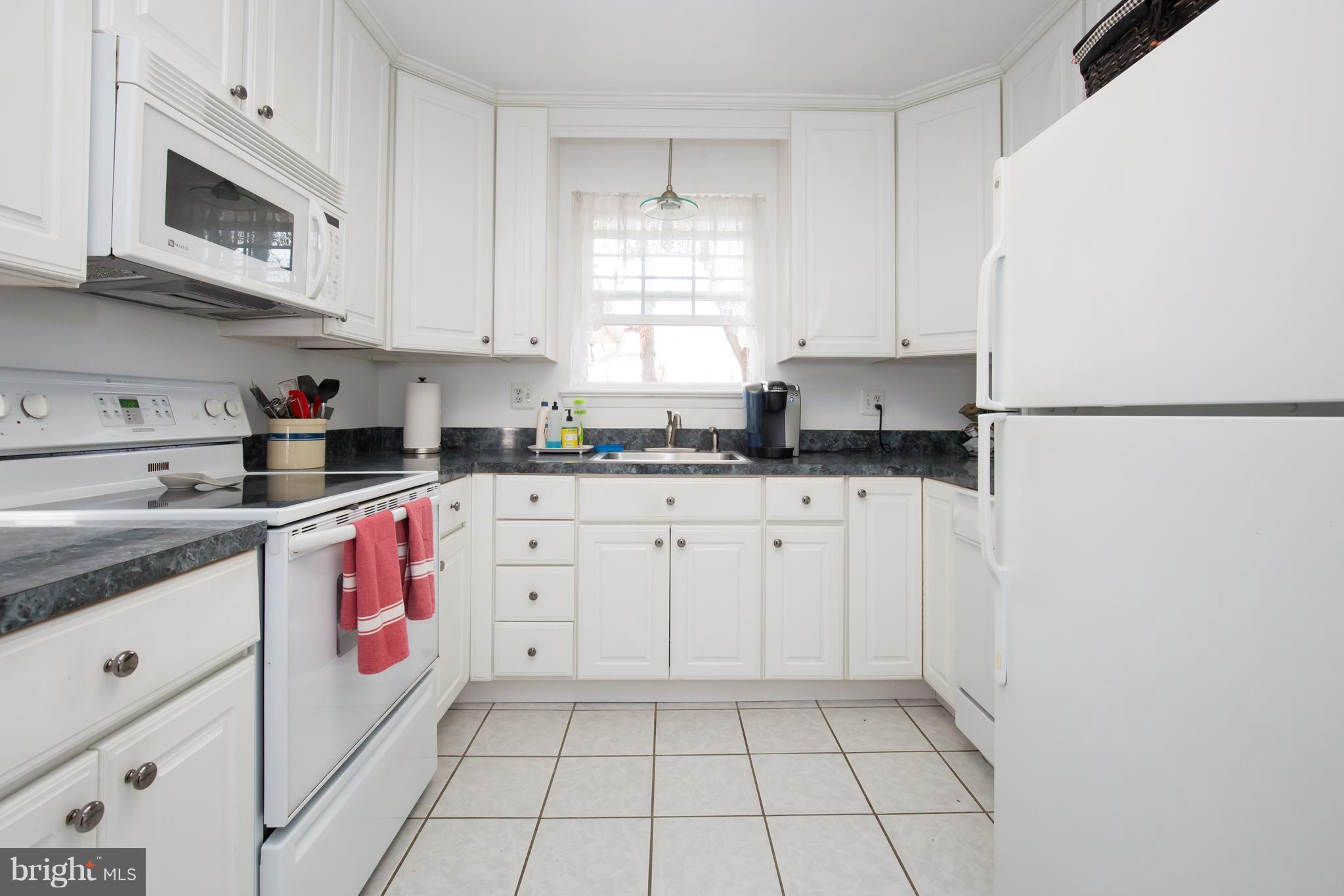5227 Milland Street Springfield, VA 22151 - Photo 13 of 28 a kitchen with granite countertop a sink a stove a microwave and cabinets