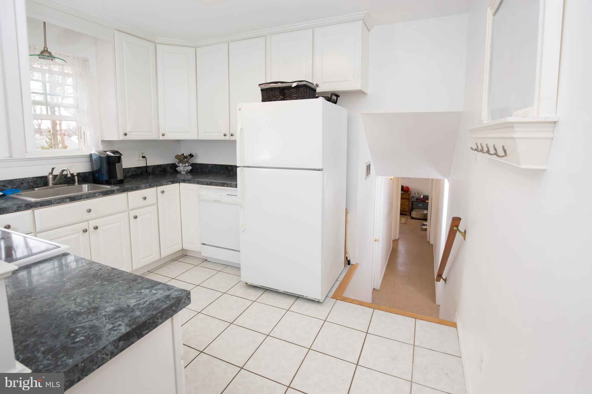 5227 Milland Street Springfield, VA 22151 - Photo 14 of 28 a kitchen with granite countertop a refrigerator sink stove and cabinets