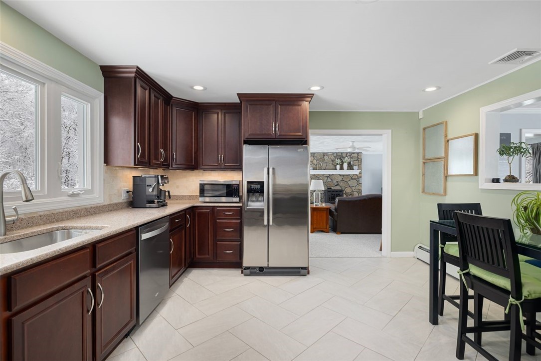 117 Moccasin Trail Cranston, RI 02921 - Photo 11 of 43 Kitchen - This custom kitchen features a spacious layout with plentiful Cherry cabinetry, ample Silestone countertop space, tile back splash with access to the living/family room.