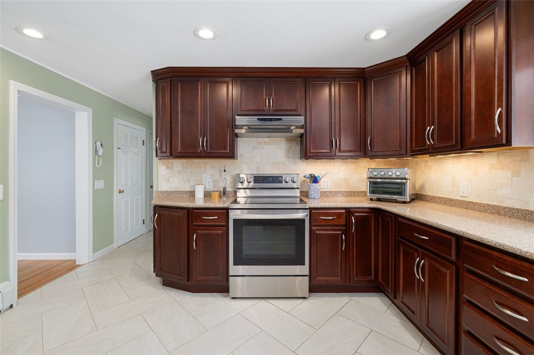 117 Moccasin Trail Cranston, RI 02921 - Photo 10 of 43 Kitchen - This stunning gourmet kitchen with custom Cherry Cabinets, tile back splash, stainless steel appliances is ready for the next chef to prepare a delicious meal.