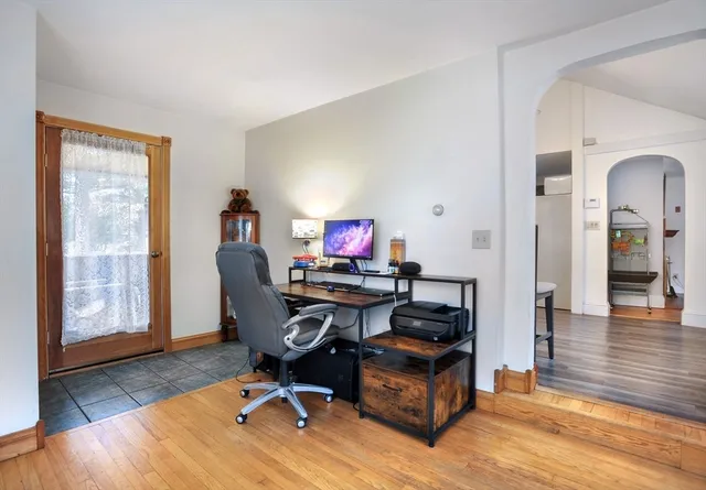 a workspace with furniture wooden floor and a window