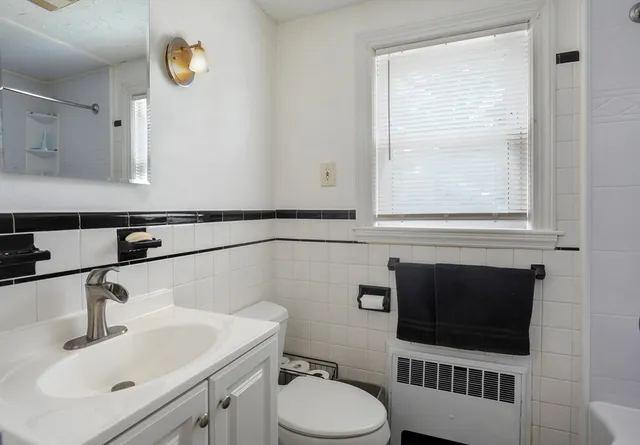 a bathroom with a sink toilet a mirror and window