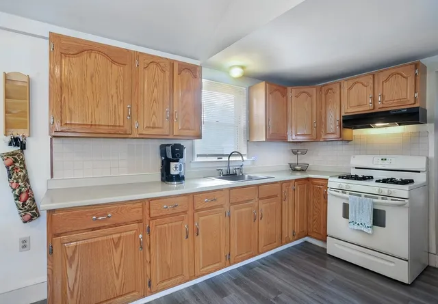 a kitchen with granite countertop wooden cabinets stainless steel appliances and a sink