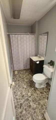 a bathroom with a toilet and a shower