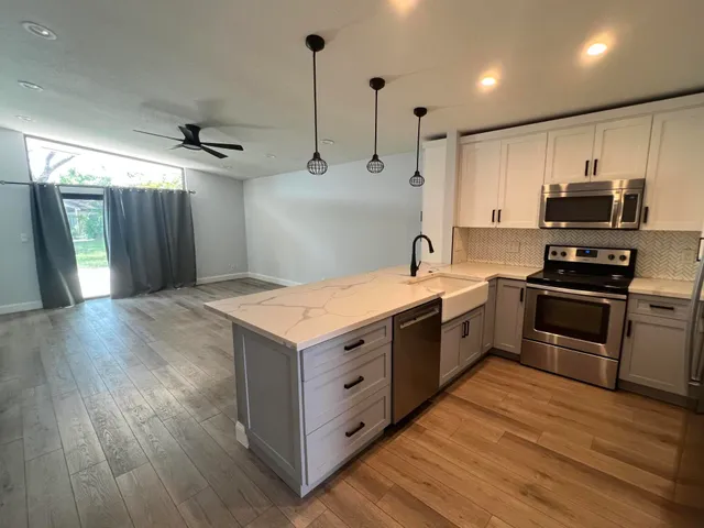 a kitchen with kitchen island white cabinets and stainless steel appliances