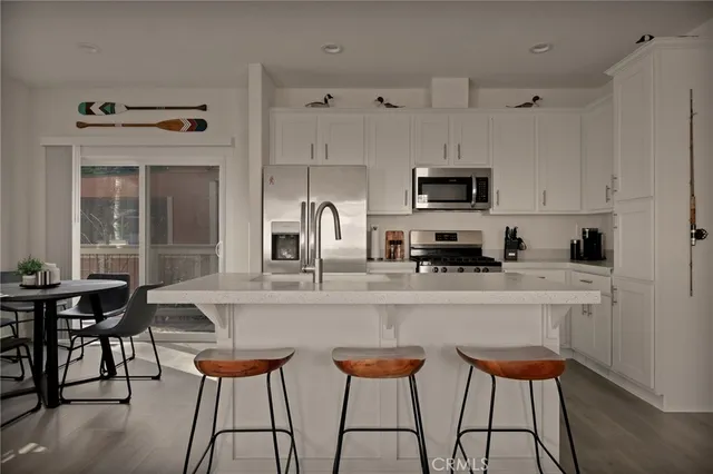 a kitchen with stainless steel appliances granite countertop a stove a sink and white cabinets