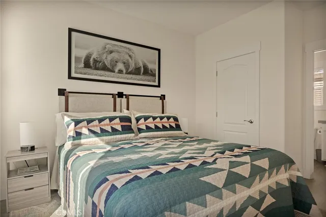 a bedroom with a bed and painting on the wall