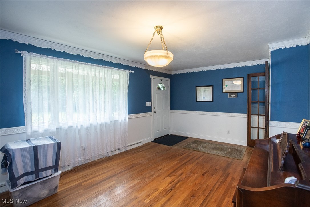 4962 Nettleton Road Medina, OH 44256 - Photo 7 of 43 Entryway with wood finished floors, wainscoting, and crown molding