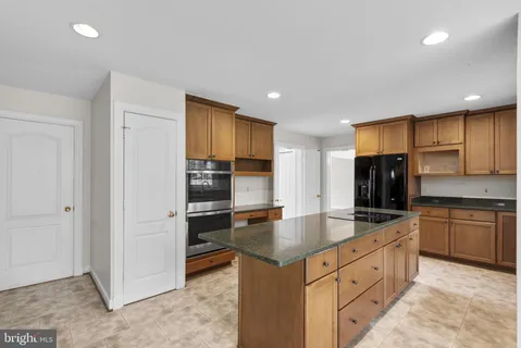 a kitchen with stainless steel appliances granite countertop a sink a stove and a refrigerator