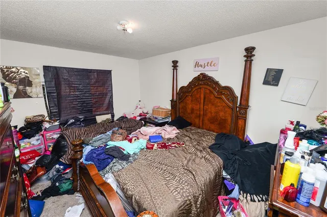 a bedroom with a bed and dresser with the shoe rack