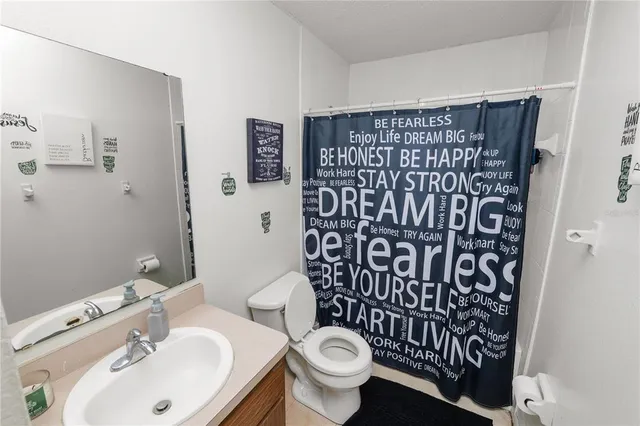 a bathroom with a sink and mirror with toilet