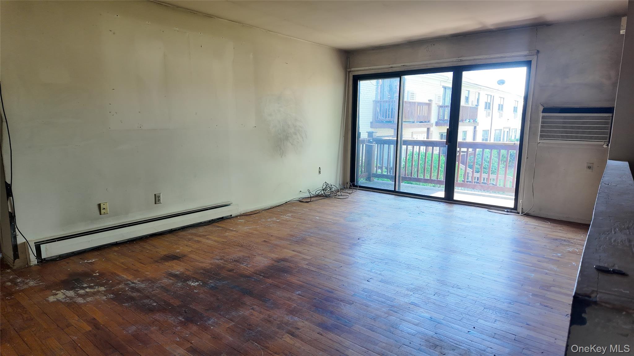 80 Sneden Place, Unit 80 Spring Valley, NY 10977 - Photo 6 of 11 Empty room featuring baseboard heating and wood-type flooring