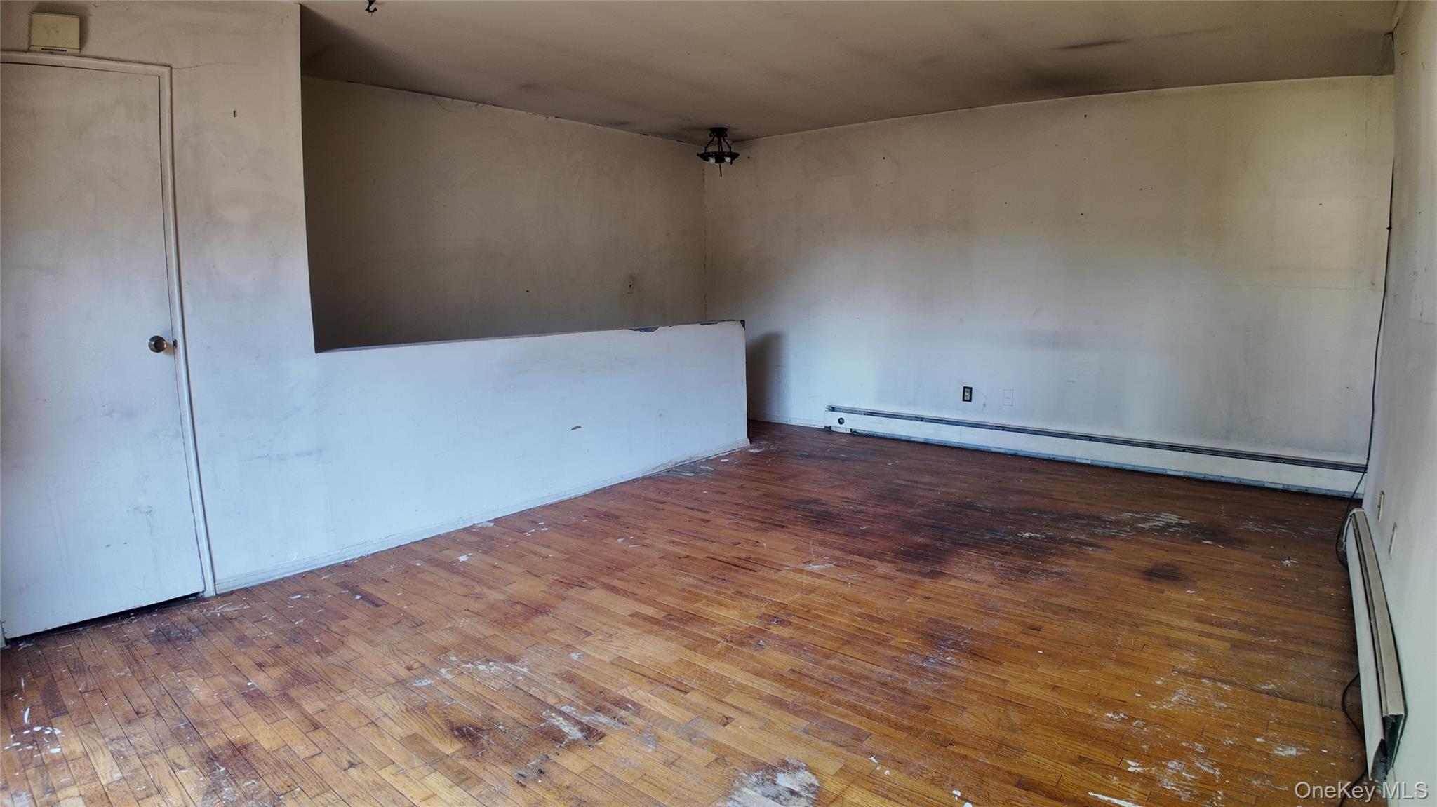 80 Sneden Place, Unit 80 Spring Valley, NY 10977 - Photo 7 of 11 Unfurnished room with a baseboard radiator, a baseboard heating unit, and hardwood / wood-style floors