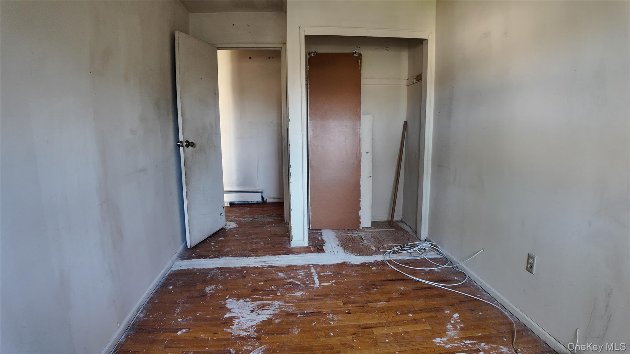 80 Sneden Place, Unit 80 Spring Valley, NY 10977 - Photo 10 of 11 Unfurnished bedroom featuring a baseboard heating unit, hardwood / wood-style flooring, and a closet