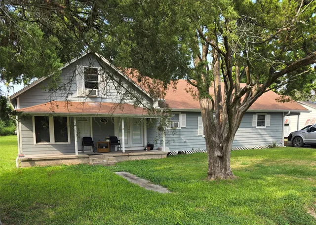 a front view of a house with a yard and green space