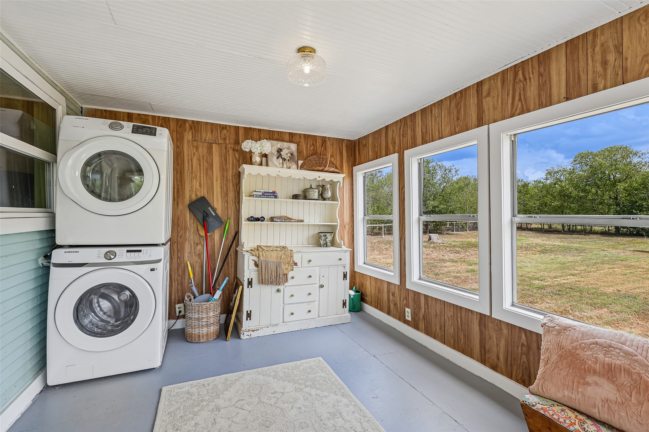372 Old Lockhart Road Lockhart, TX 78644 - Photo 26 of 40 Rich wood paneling and large picture windows framing green pastures define this bright utility space.