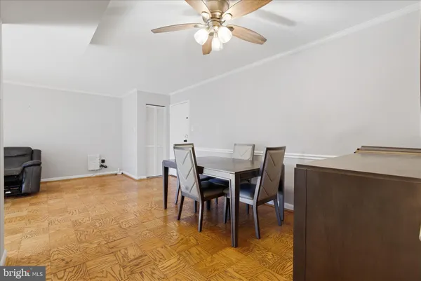 a dining room with furniture and a chandelier fan