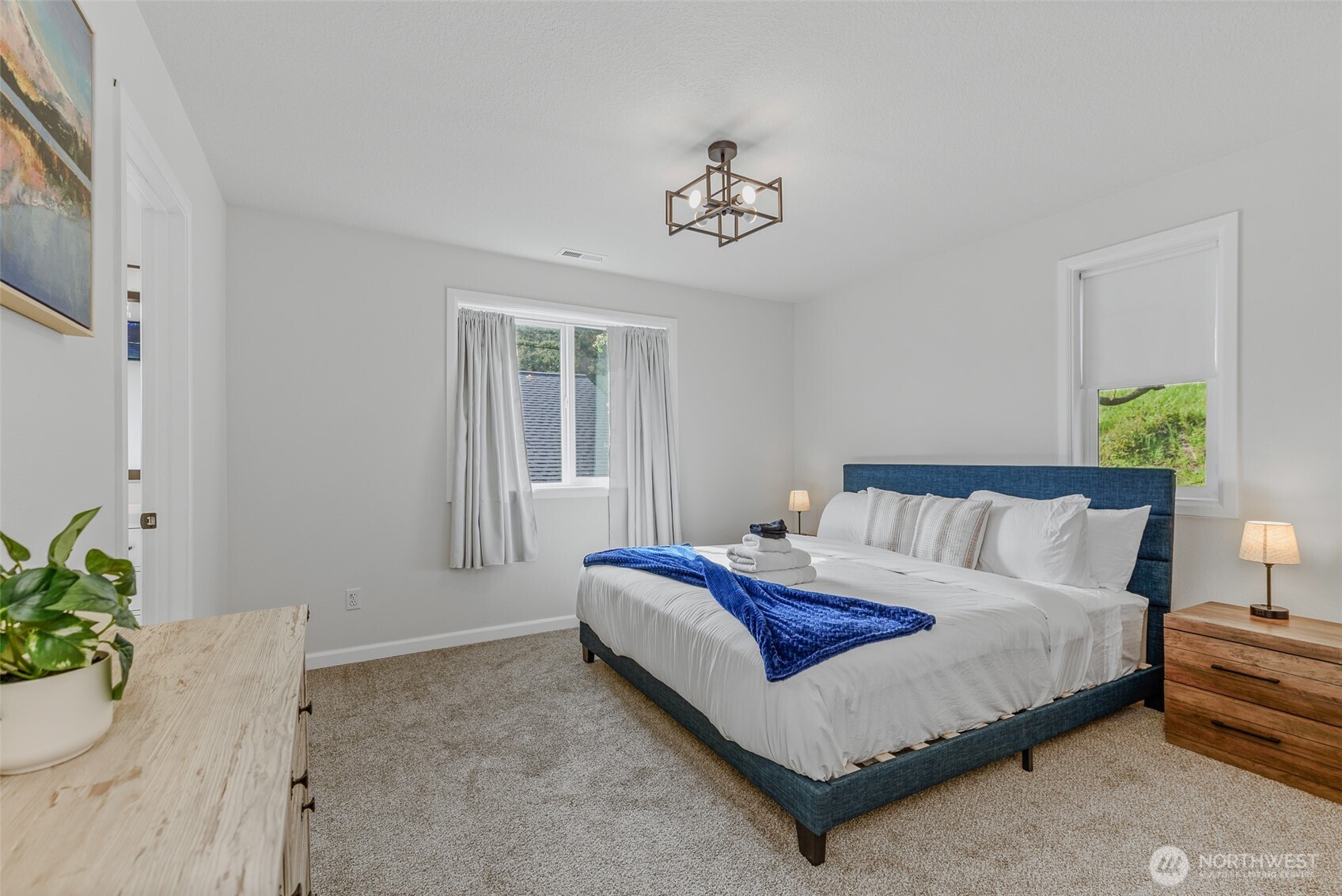 461 Northwest Jefferson Street Stevenson, WA 98648 - Photo 22 of 38 a spacious bedroom with a bed and a chandelier