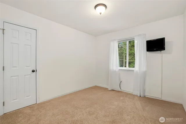 an empty room with windows and television