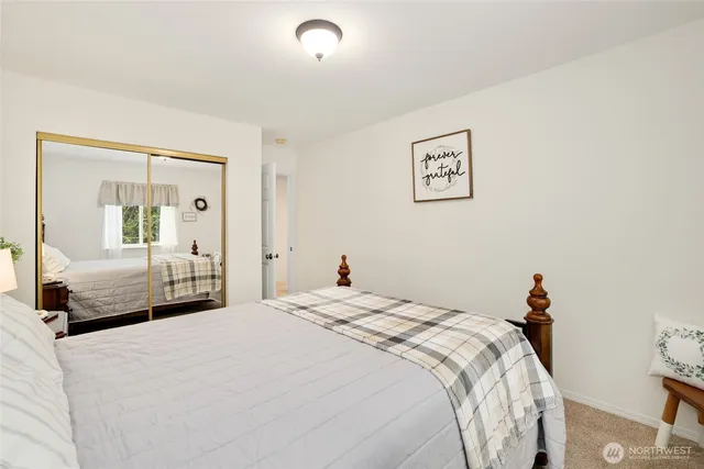 a bedroom with a bed and a large mirror