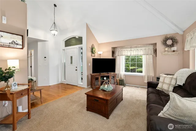 a living room with furniture a flat screen tv and a large window