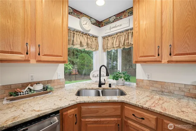 a kitchen with granite countertop a sink stainless steel appliances and cabinets