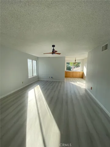 a view of empty room with wooden floor and window