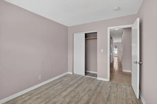 a view of a livingroom with wooden floor and a bathroom