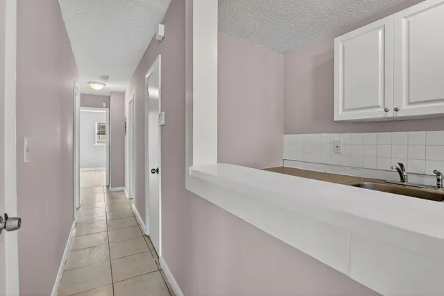 a hallway with view of bathroom and mirror