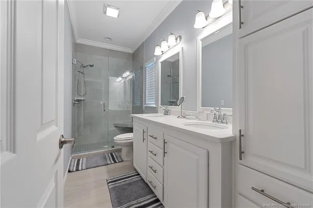 a spacious bathroom with a double vanity sink a mirror and a shower