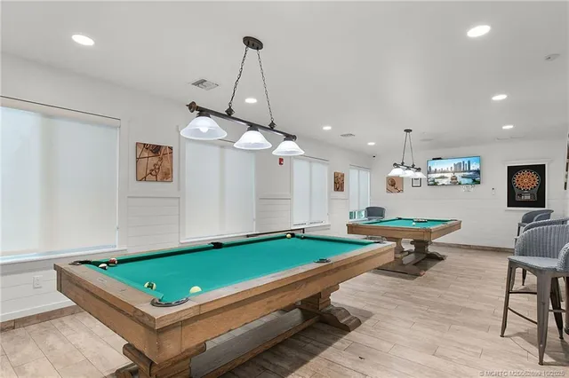 a room with furniture pool table and a chandelier
