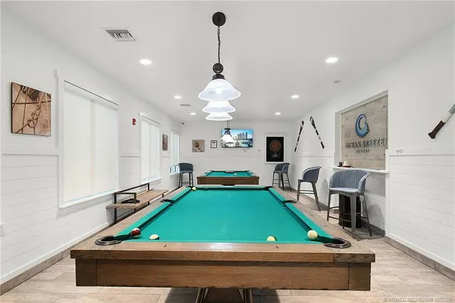 a room with pool table and windows